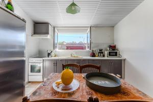a kitchen with a table with an orange on it at La Chambre Dorée du Bassin in La Teste-de-Buch +12 photos