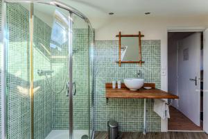 a bathroom with a glass shower and a sink at La Chambre Dorée du Bassin in La Teste-de-Buch