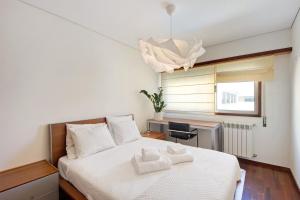 a bedroom with a bed with two towels on it at Cantinho da Praia da Barra in Gafanha da Nazaré +16 photos
