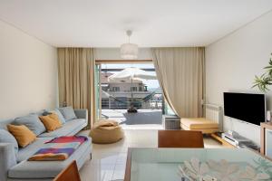 a living room with a couch and a tv at Cantinho da Praia da Barra in Gafanha da Nazaré