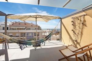 a hammock on a balcony with a view of a building at Cantinho da Praia da Barra in Gafanha da Nazaré