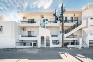 an apartment building with a staircase in a parking lot at Dorothy's Seaview Apartment in Haraki