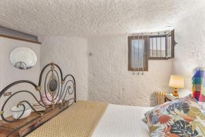 a bedroom with a bed with a wrought iron headboard at Finca Cuevas La Solana in Gáldar