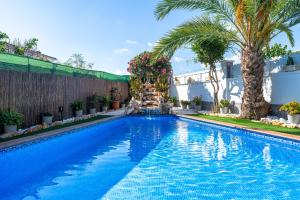 a swimming pool with palm trees and a building at Traditional Villa in Creixell