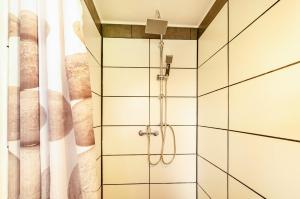 a shower in a bathroom with white tiles at Möwchen in Berumbur +37 photos