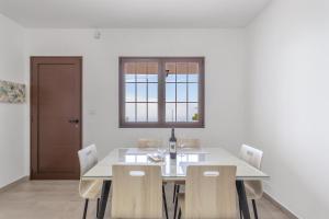 a dining room with a white table and chairs at Casa Tajinaste in Tijarafe