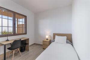a bedroom with a bed and a desk and a window at Casa Tajinaste in Tijarafe