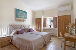 a bedroom with a bed and a desk and window at Villa Nicola in Vale do Lobo +23 photos