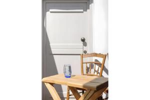 a wooden table and a chair with a glass on it at Echinousa Kimolos katoikia no2 in Kimolos