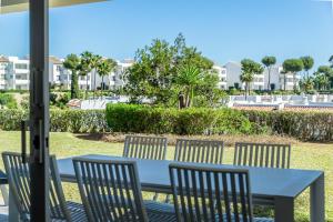a table and chairs on a patio with a view of condos at 2bed apartment in Miraflores in Mijas