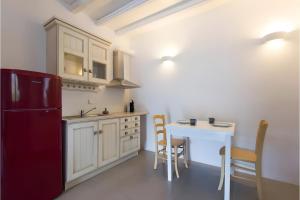 a kitchen with a red refrigerator and a table at Echinousa Kimolos katoikia no2 in Kimolos