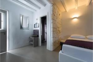 a bedroom with a bed and a stone wall at Echinousa Kimolos katoikia no2 in Kimolos