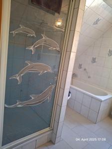 a bathroom with a shower with dolphins on the glass at Im Grünen 2 in Weil der Stadt +11 photos