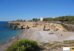 a beach with a rocky shoreline and the ocean at Villa Monbijou in Vinarós