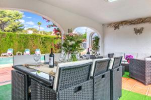 a patio with a table with wine glasses and flowers at El Horreo Xabia in El Tosalet