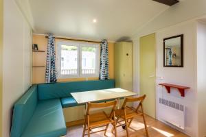 a small room with a table and chairs at Mobilhome Le Chene in Saint-Pompont