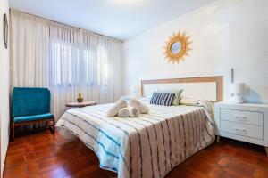 a bedroom with a bed and a blue chair at Villa Monbijou in Vinarós +24 photos