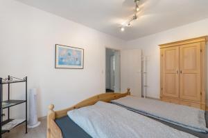 a bedroom with a bed and a wooden cabinet at Casa Rolando in Nördlingen