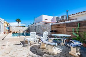 a patio with chairs and a table and a table and chairs at Villa Monbijou in Vinarós