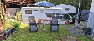 an rv parked in a yard with an umbrella at Im Grünen 2 in Weil der Stadt