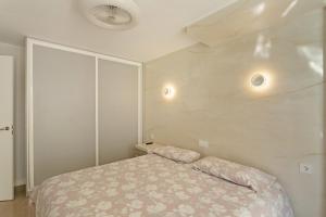 a bedroom with a bed and two lights on the wall at Kellys' Apartment Las Camelias in San Bartolomé +12 photos
