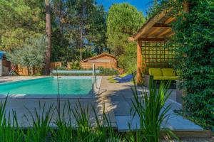 a backyard with a swimming pool and a gazebo at La maisonnette en bois in Saumos