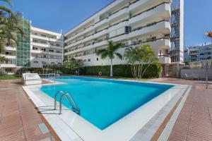 a swimming pool in front of a building at Kellys' Apartment Las Camelias in San Bartolomé