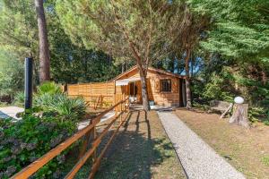 a wooden cabin with a fence in front of it at La maisonnette en bois in Saumos