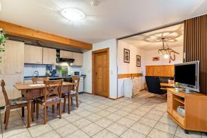 a kitchen and dining room with a table and a television at Ferienwohnung Brandenkopf in Oberharmersbach