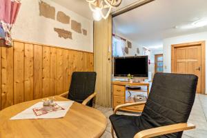 a living room with a table and chairs and a television at Ferienwohnung Brandenkopf in Oberharmersbach