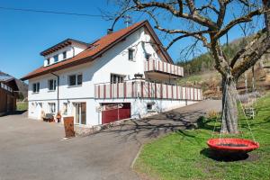 a white house with a tree in front of it at Albpartments in Meßstetten