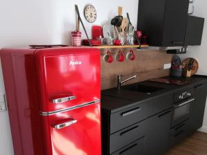 a red refrigerator in a kitchen next to a sink at Ferienwohnung Gugel, 48qm in Kandern