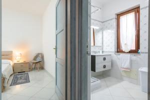 a white bathroom with a bed and a sink at Casa Celeste in Villasimius +19 photos