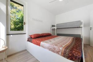 a bedroom with a bed and a window at Ghome and Home Lake view Apartment in Civenna