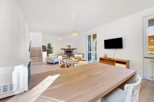 a living room with a dining room table and a tv at Ghome and Home Lake view Apartment in Civenna
