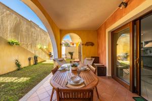 an outdoor patio with a wooden table and chairs at Casa Celeste in Villasimius