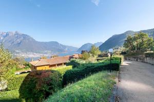 a house on a hill next to a road at Ghome and Home Lake view Apartment in Civenna