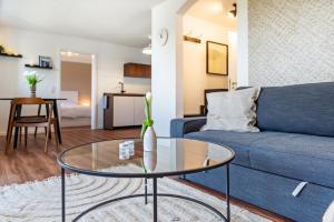 a living room with a blue couch and a glass table at Ferienwohnung Reichle in Stockach