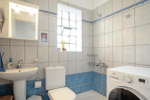 a bathroom with a toilet and a sink and a washing machine at Casa Miranda in Kefallonia +22 photos