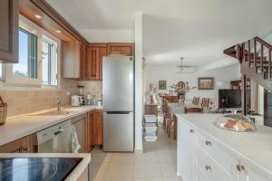 a kitchen with a refrigerator and a dining room at Casa Miranda in Kefallonia