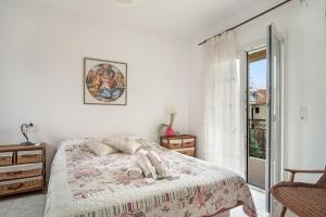 a white bedroom with a bed and a window at Casa Miranda in Kefallonia