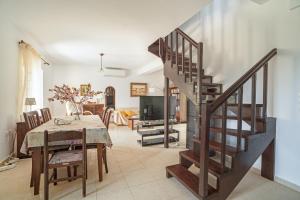 a staircase in a living room with a table and a dining room at Casa Miranda in Kefallonia