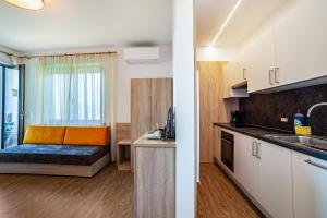 a kitchen with a couch in the middle of a room at Gartenheim App Josef in Schenna