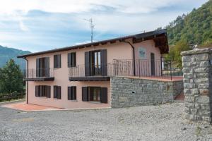 a house with a balcony and a stone wall at Chalet La Greta con vista in Firenzuola