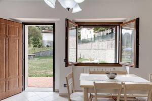a dining room with a table and chairs and windows at Chalet La Greta con vista in Firenzuola