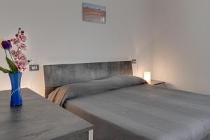 a bedroom with a bed and a vase of flowers on a table at Chalet La Greta con vista in Firenzuola