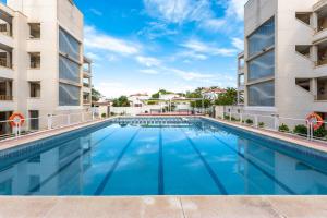 a swimming pool in front of two buildings at Apartamento Pelicano in Cambrils