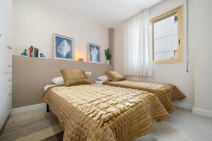 a bedroom with two beds and a window at Apartamento Pelicano in Cambrils +20 photos