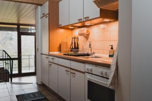 a kitchen with white cabinets and a sink at Ferienwohnungen Bullau - 2 in Erbach