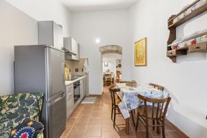 a kitchen with a table with chairs and a refrigerator at Affittacamere Le Muse in Scano Montiferro